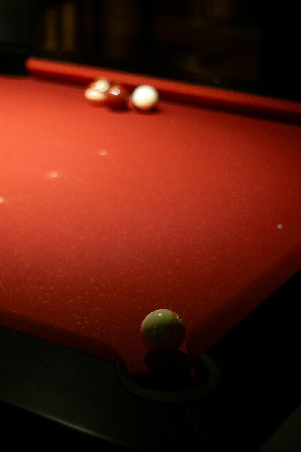 une table de billard rouge avec deux balles dessus