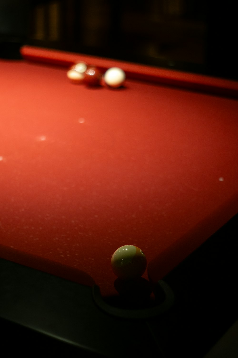 a red pool table with two balls on it