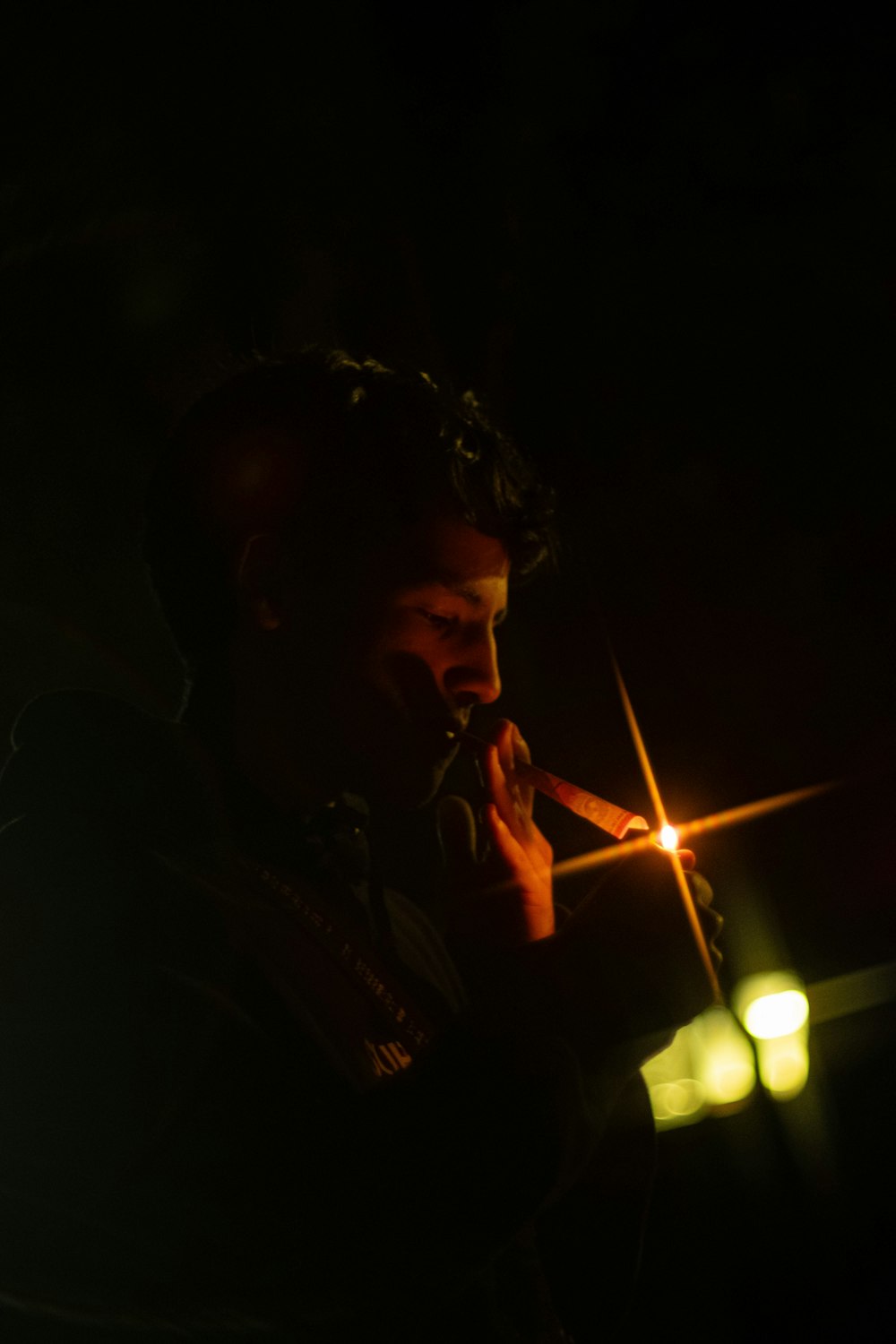 a man smoking a cigarette in the dark