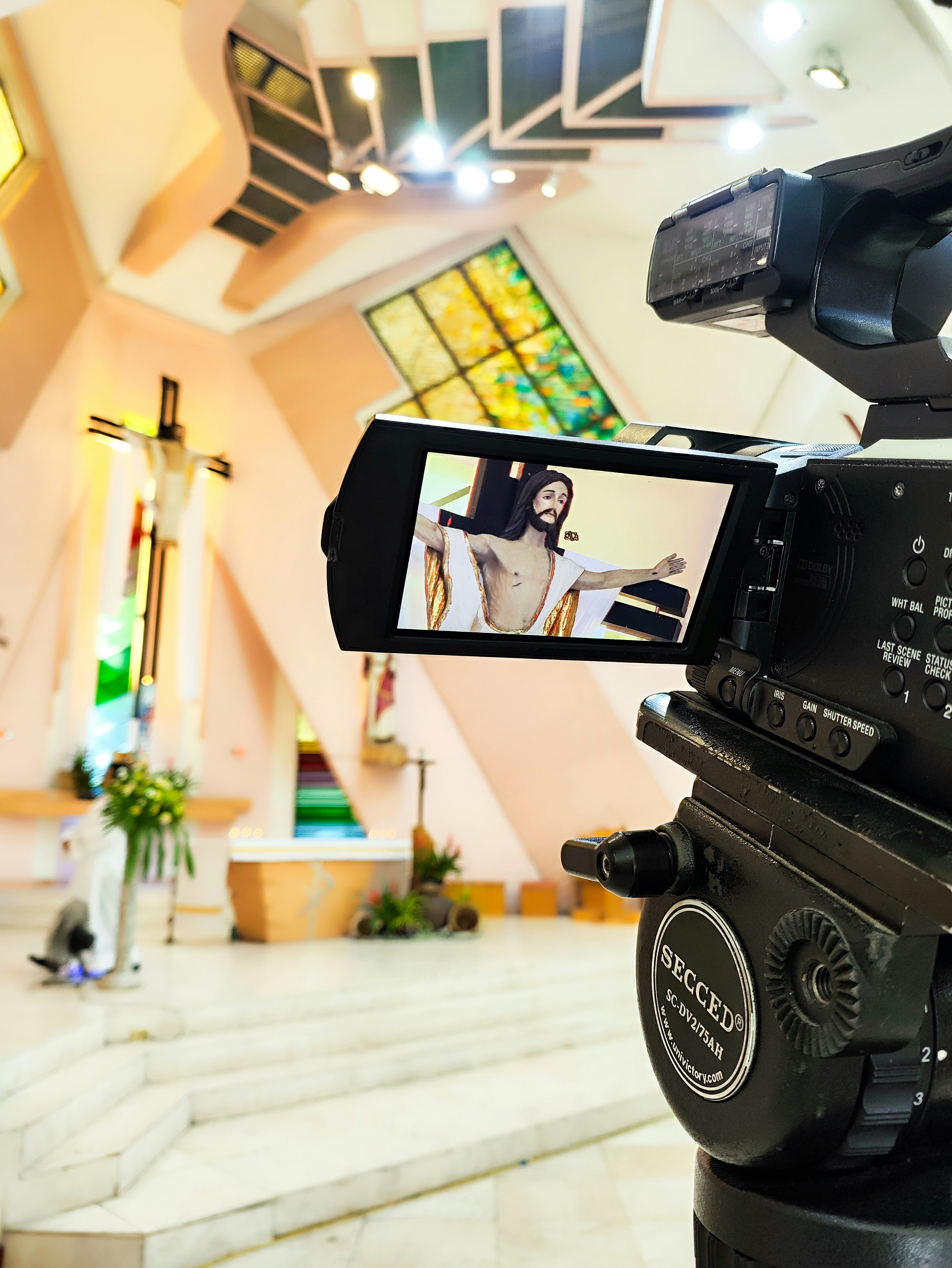 eine Videokamera, die eine Frau in einer Kirche aufnimmt