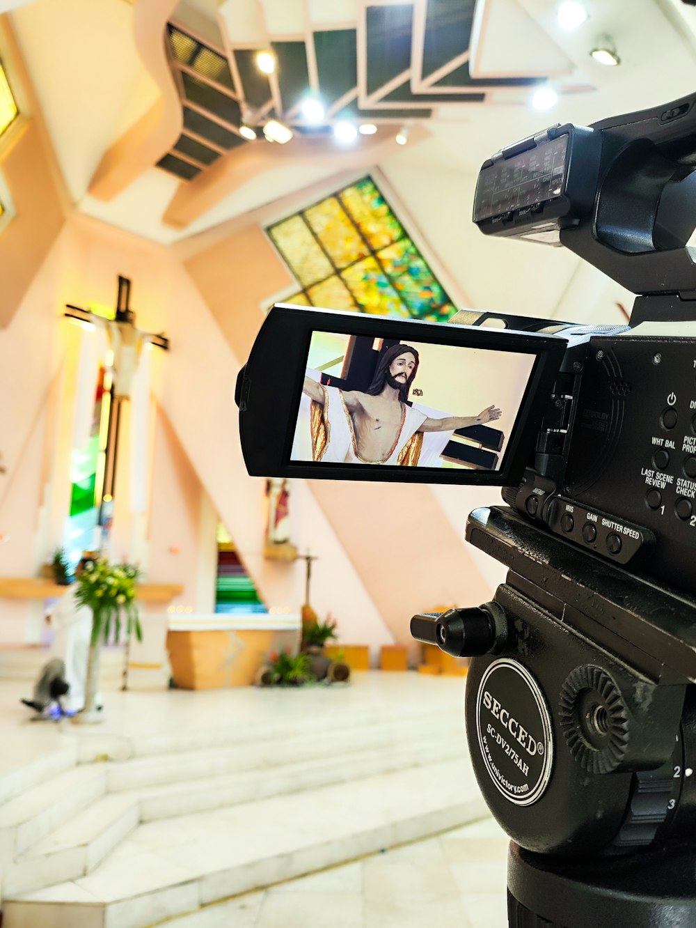 a video camera recording a woman in a church