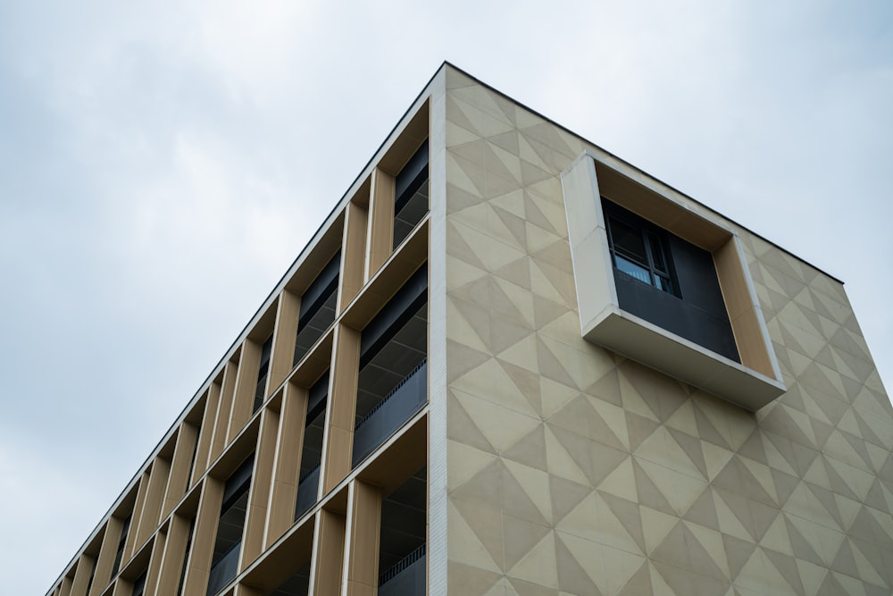 a tan building with a window and a sky background