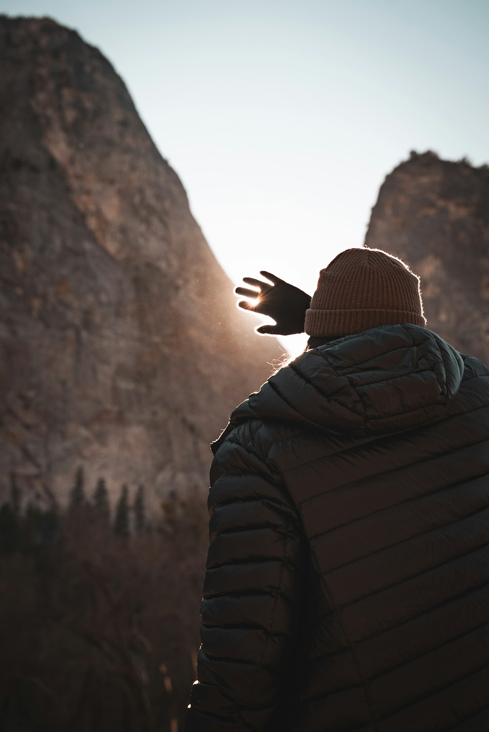 a person with their hands out in front of a mountain