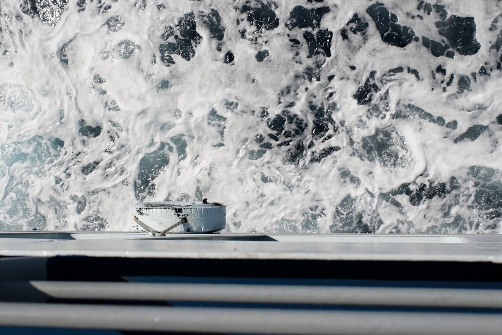 a cup sitting on top of a table next to a wave