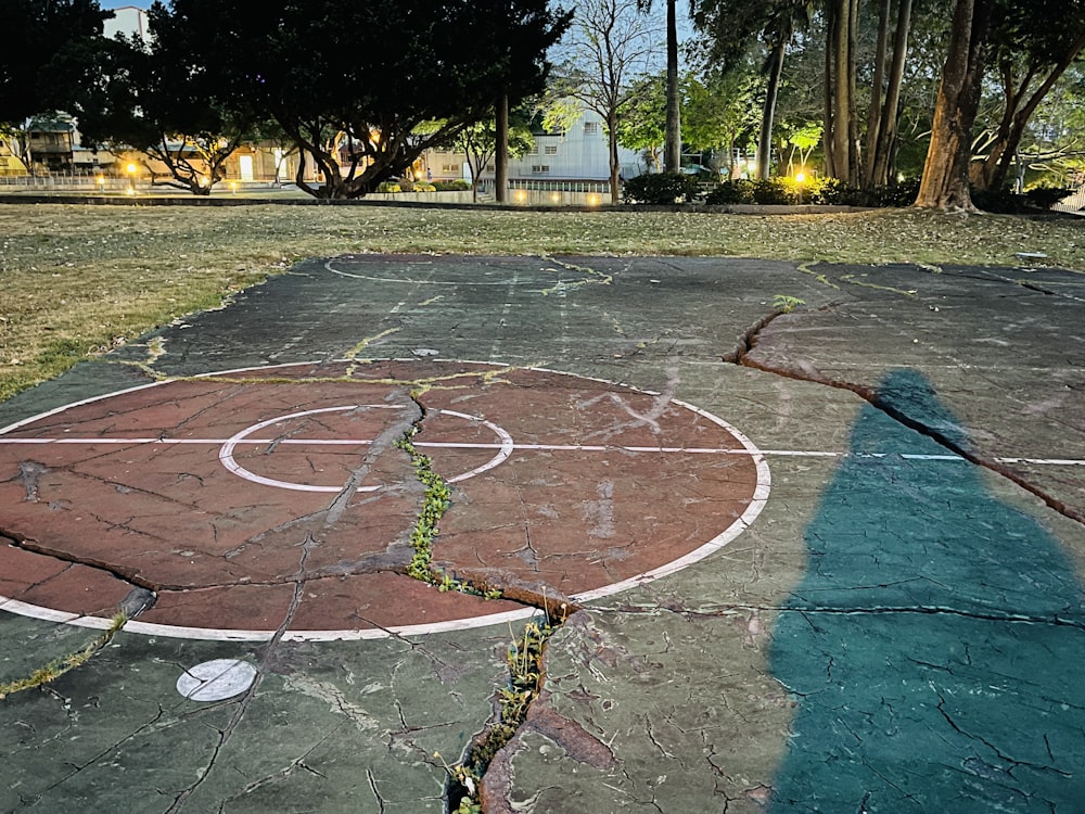 a basketball court in a park with trees in the background