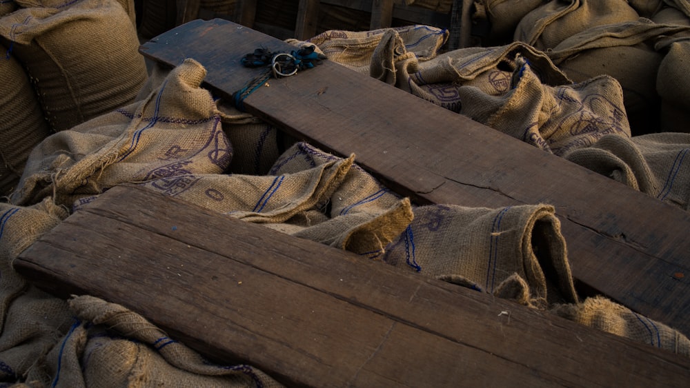 a pile of bags with a wooden board on top of it