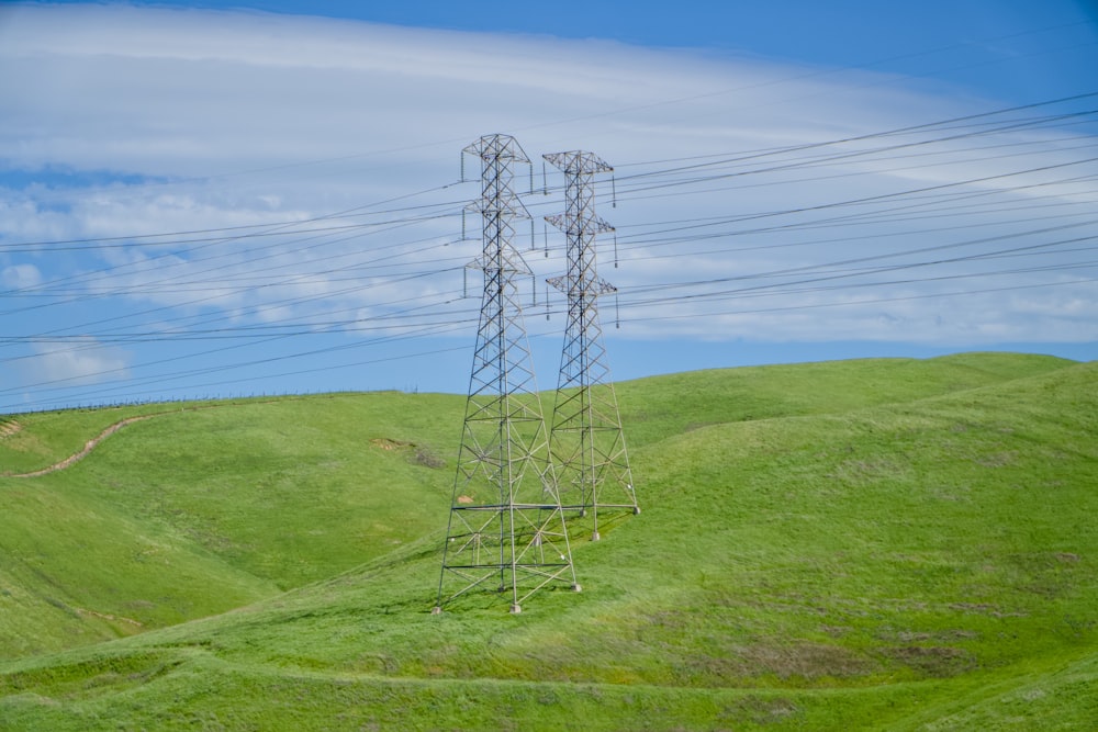 a high voltage power line on a green hillside