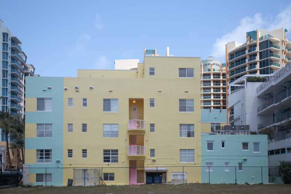 a multi - colored building in a city with tall buildings in the background