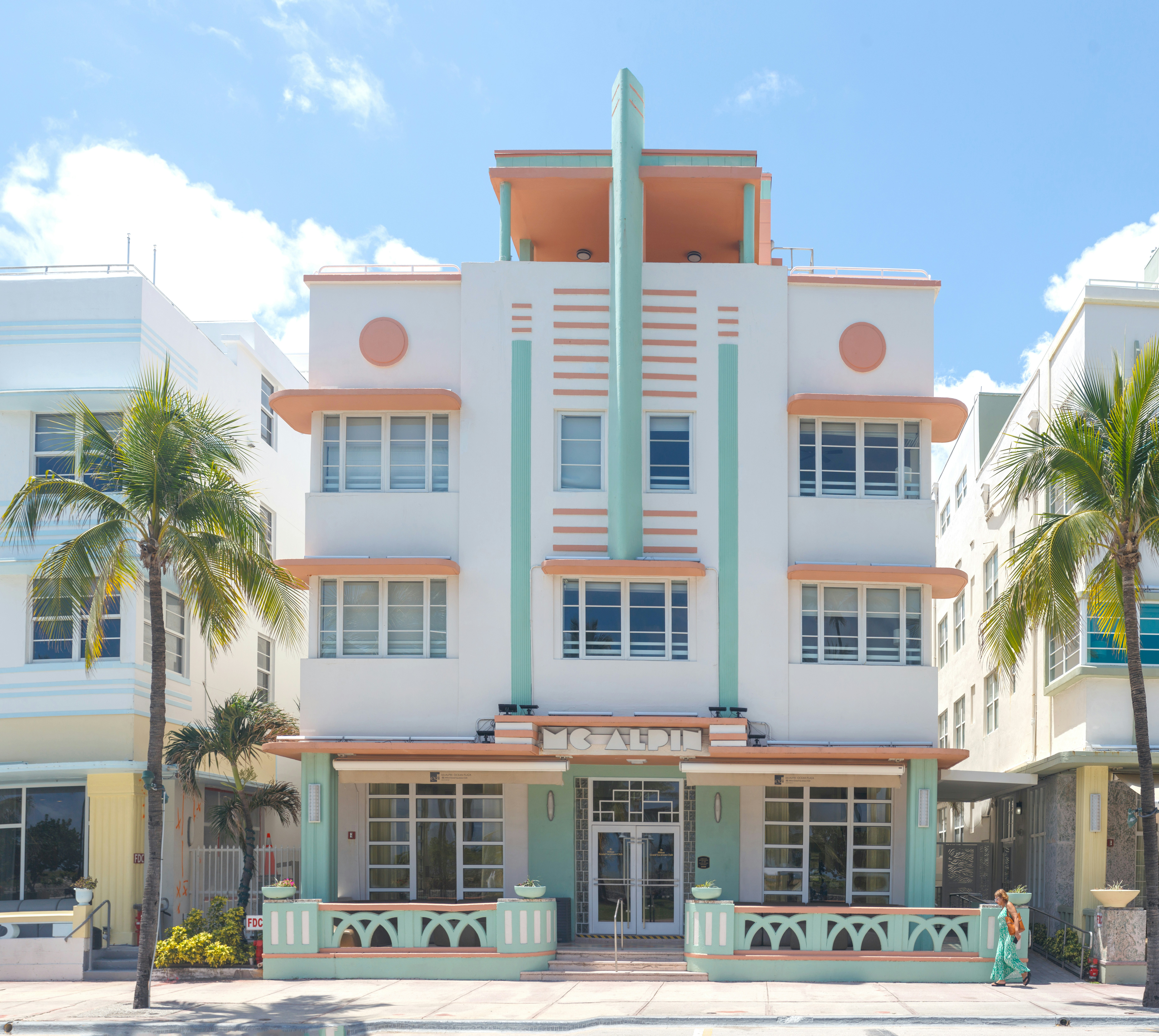 a large white building with palm trees in front of it