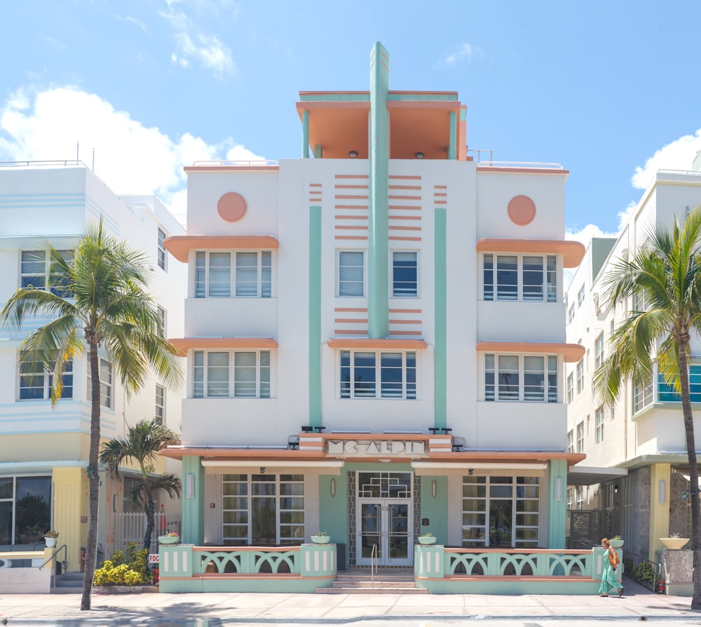 a large white building with palm trees in front of it