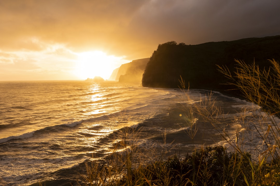 the sun is setting over the ocean on a cloudy day, Dramatischer Sonnenaugang an den Klippen von Hawaii.