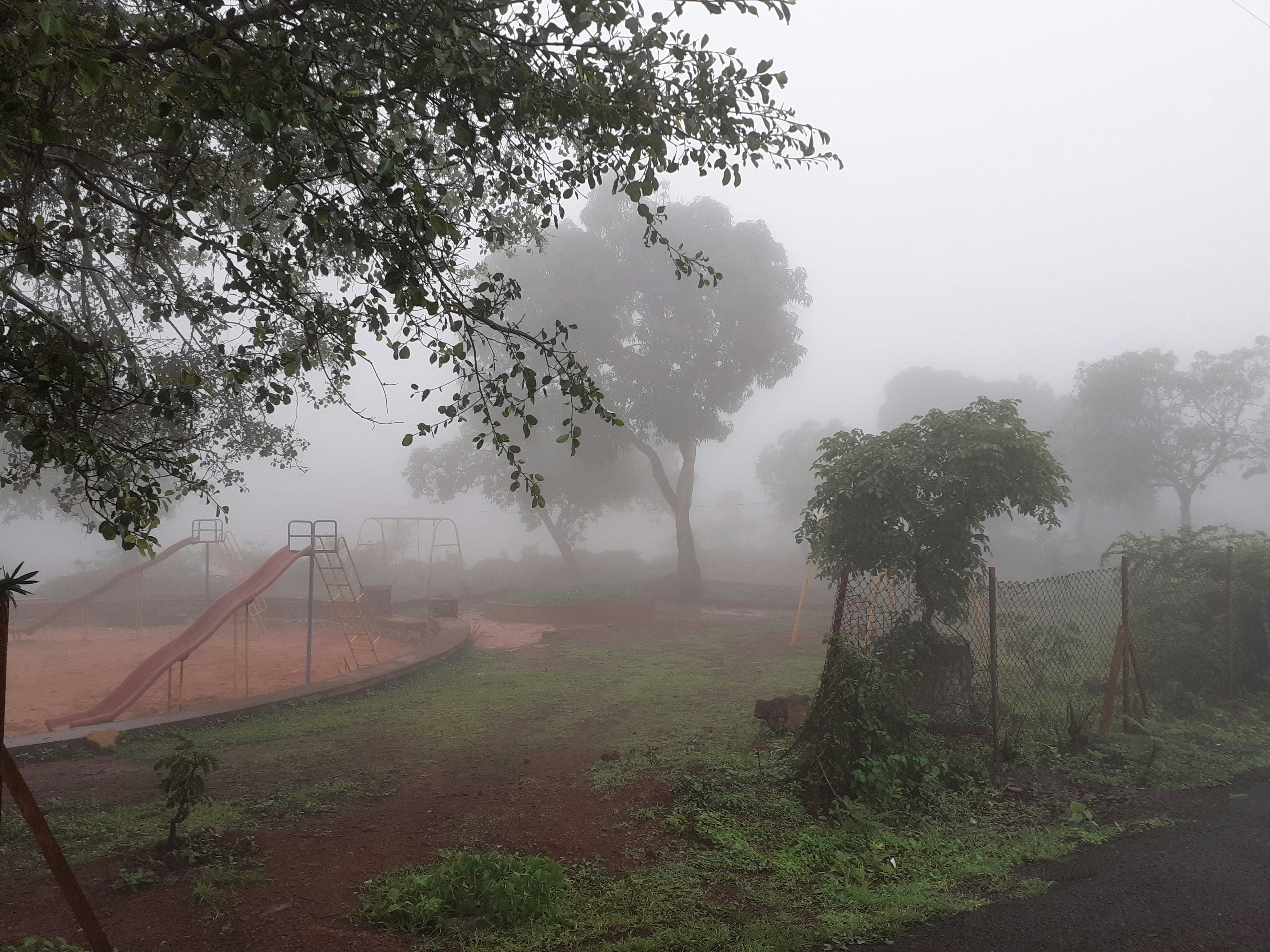 a park with a swing set in the fog