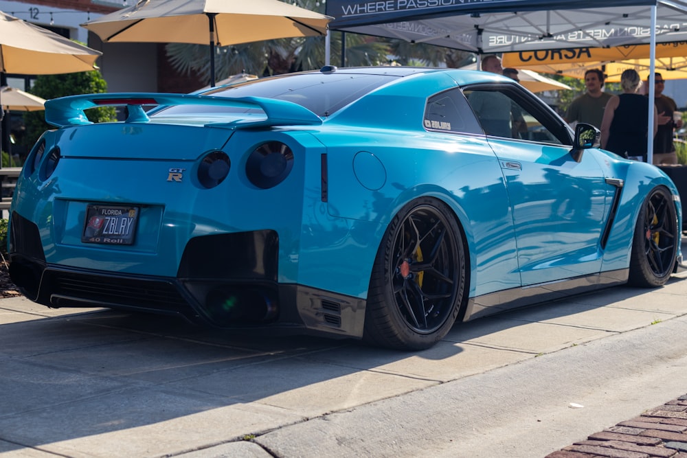 a blue sports car parked on the side of the road