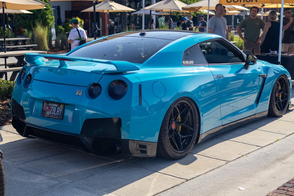 a blue sports car parked on the side of the road