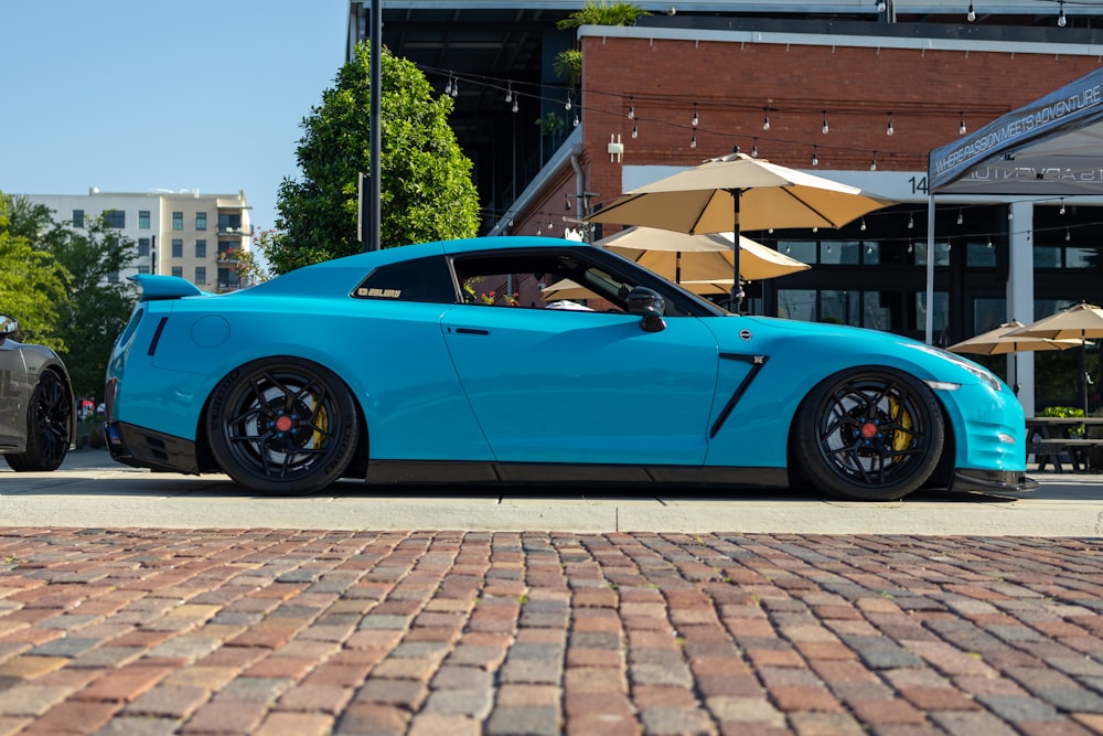 a blue sports car parked in front of a building