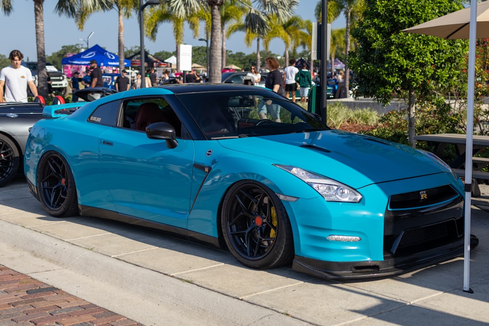 a blue sports car parked on the side of the road