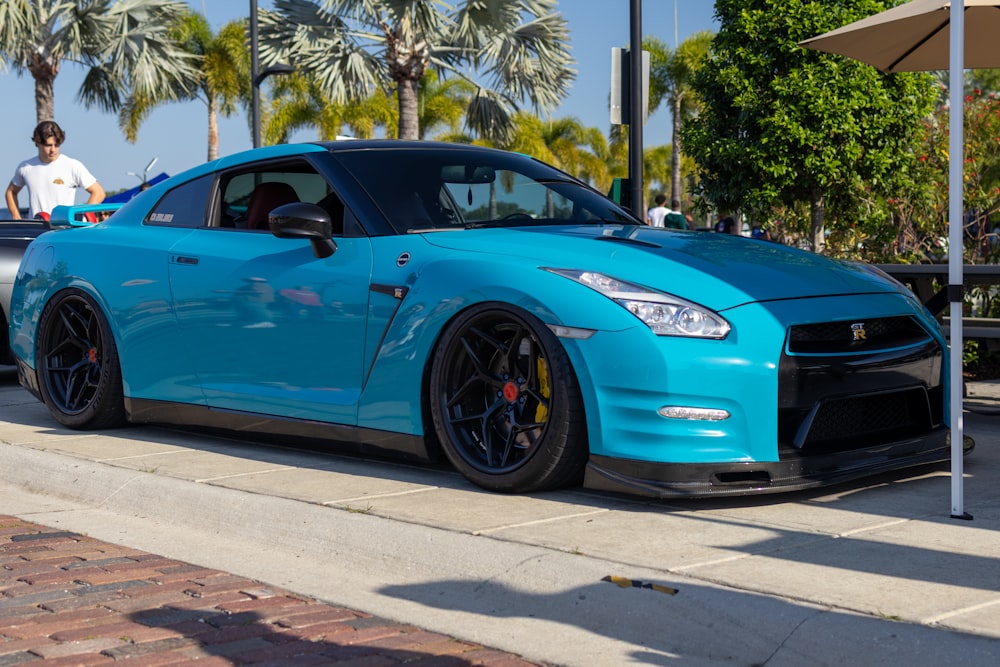 a blue sports car parked on the side of the road