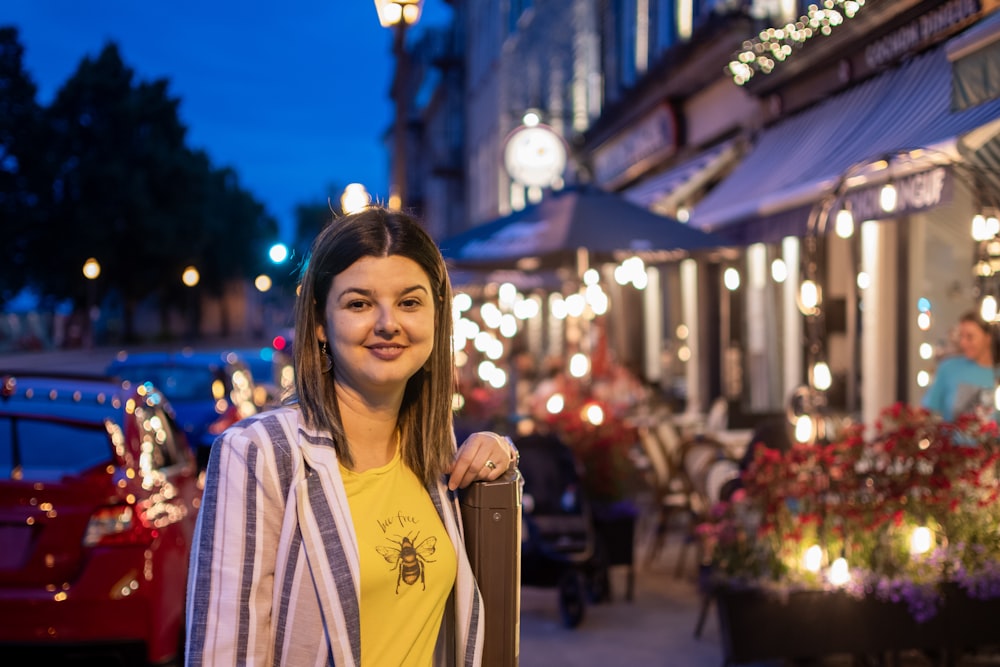 a woman standing in front of a building at night