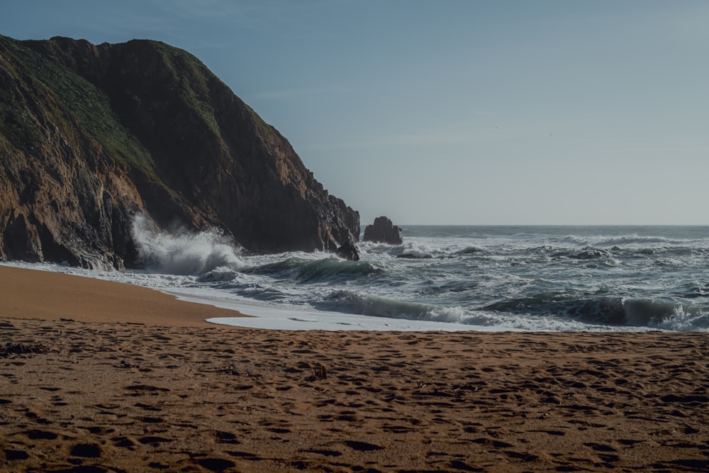 a sandy beach with waves coming in to shore