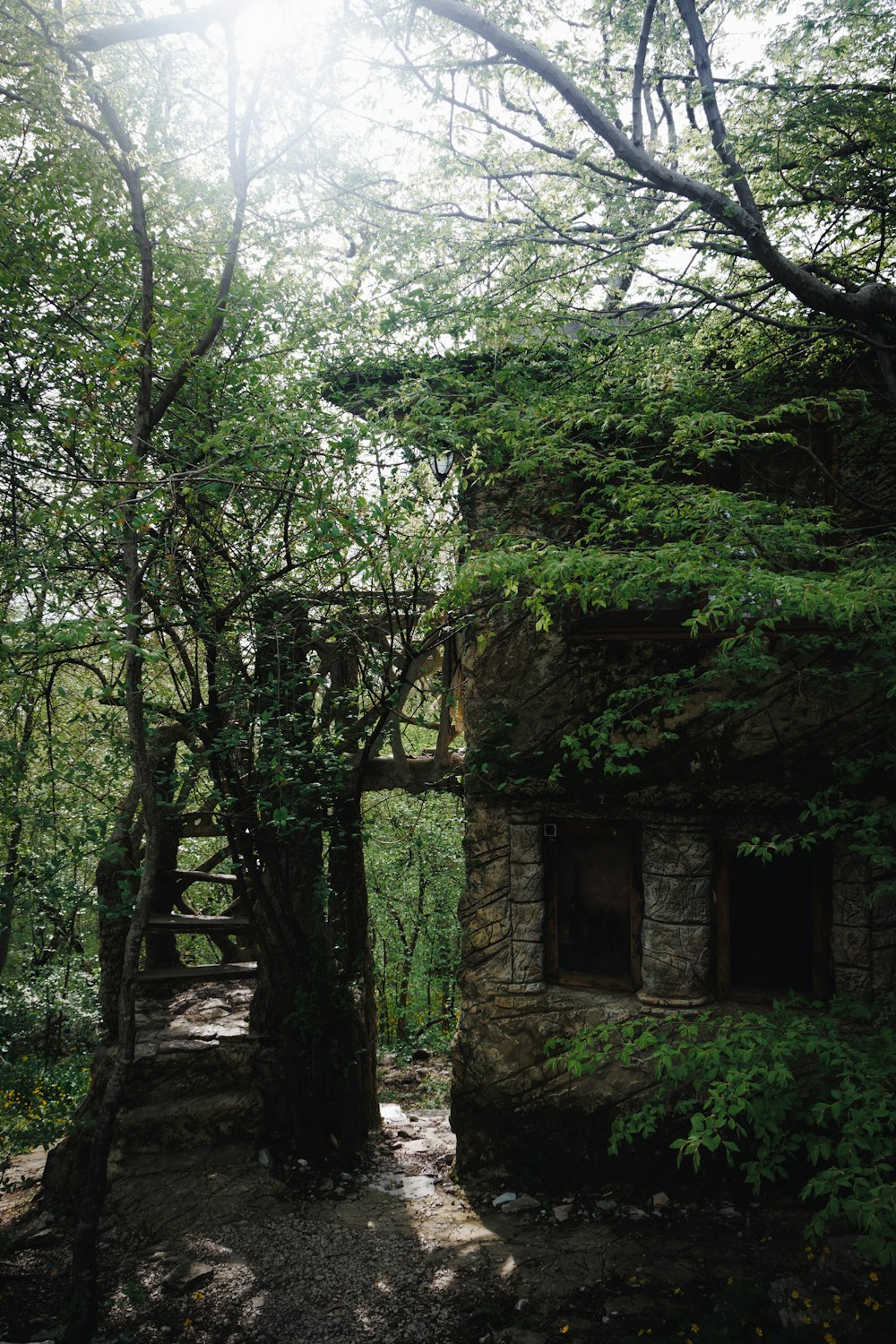 a stone building surrounded by trees in a forest