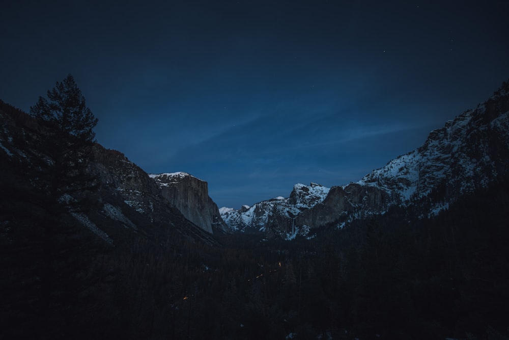 a mountain covered in snow under a dark sky