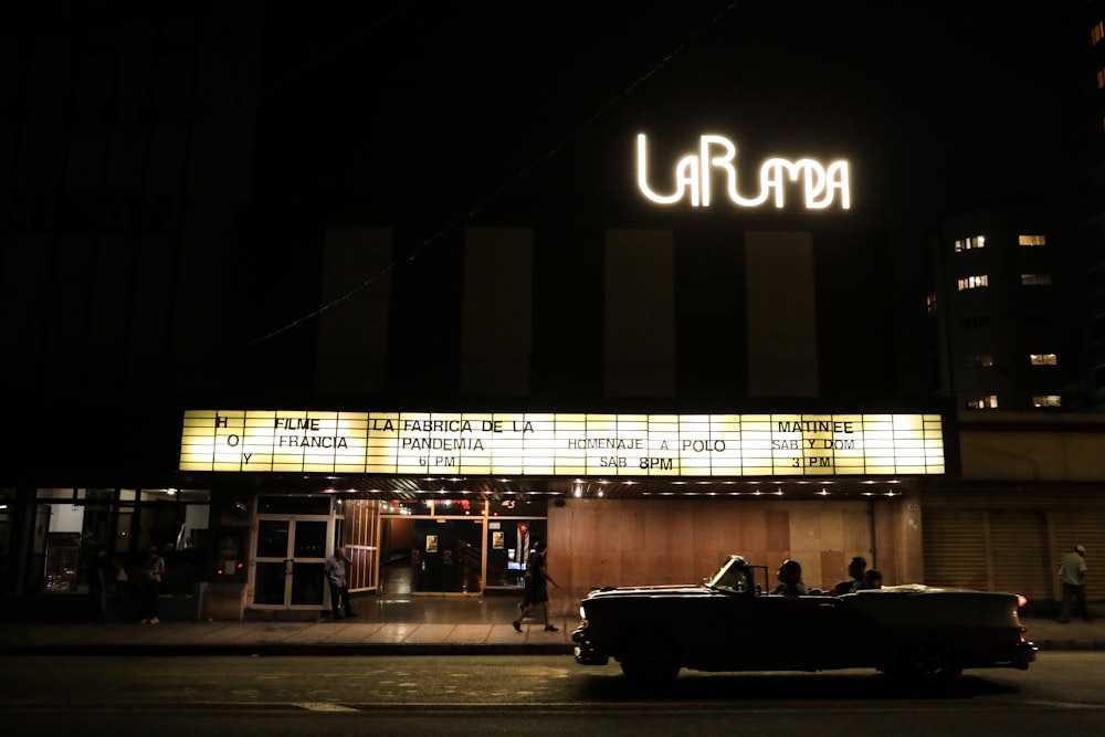 a car parked in front of a theater at night