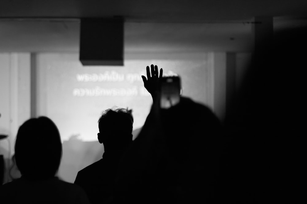 a group of people standing in front of a projection screen