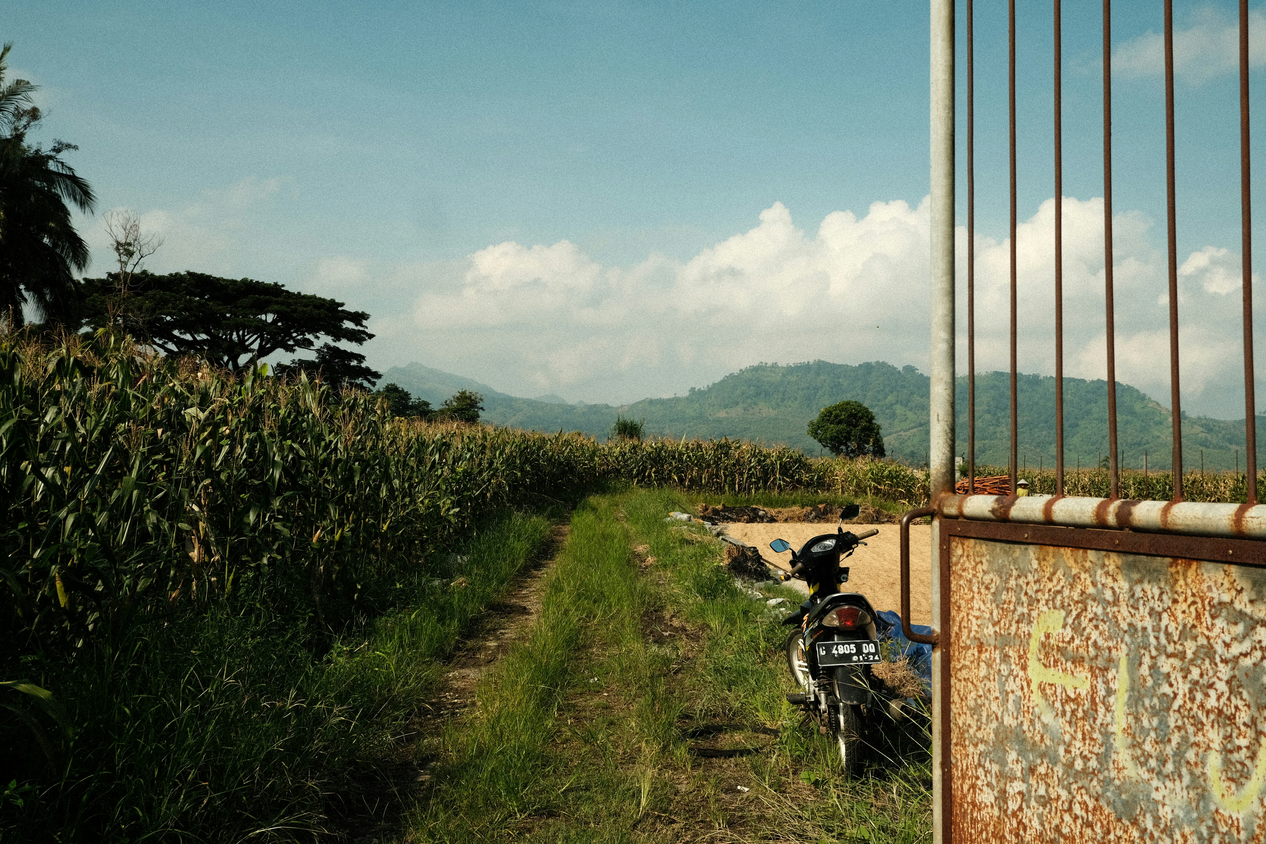 a dirt road with a motorcycle parked on the side of it