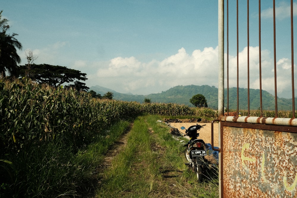 a dirt road with a motorcycle parked on the side of it