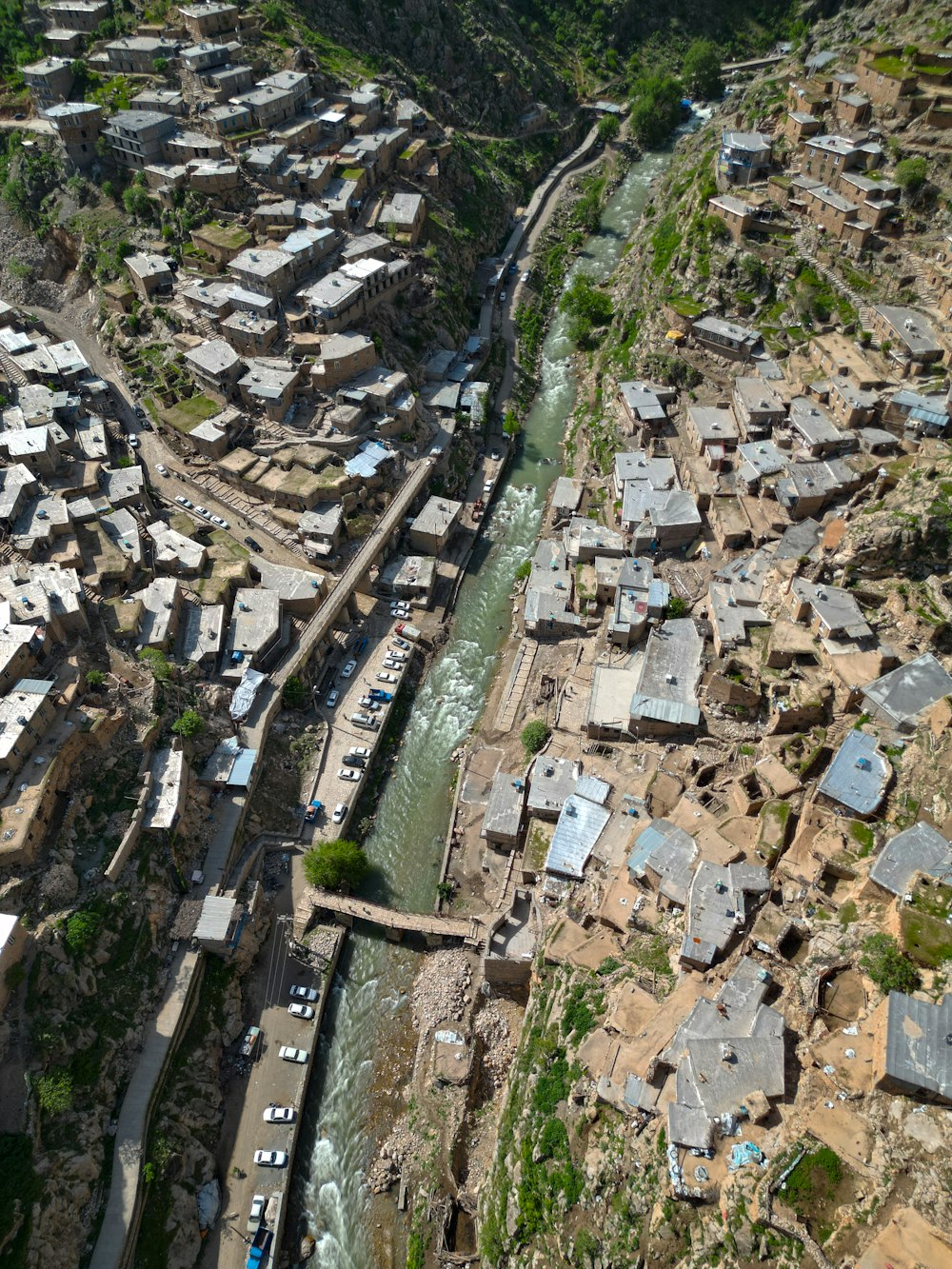 an aerial view of a river running through a village