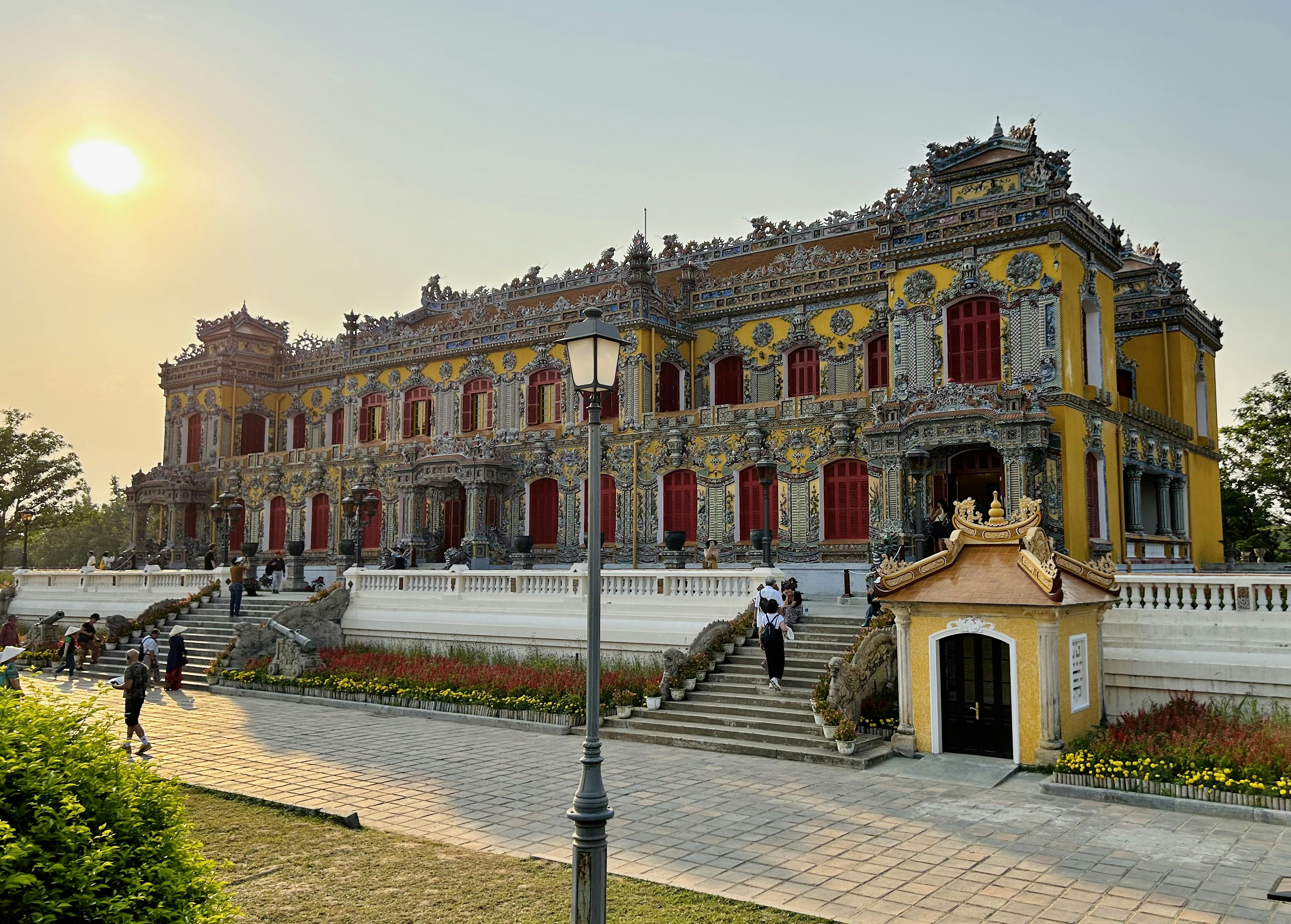a yellow and white building with red shutters