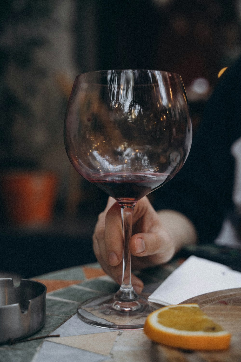 a person holding a glass of wine at a table