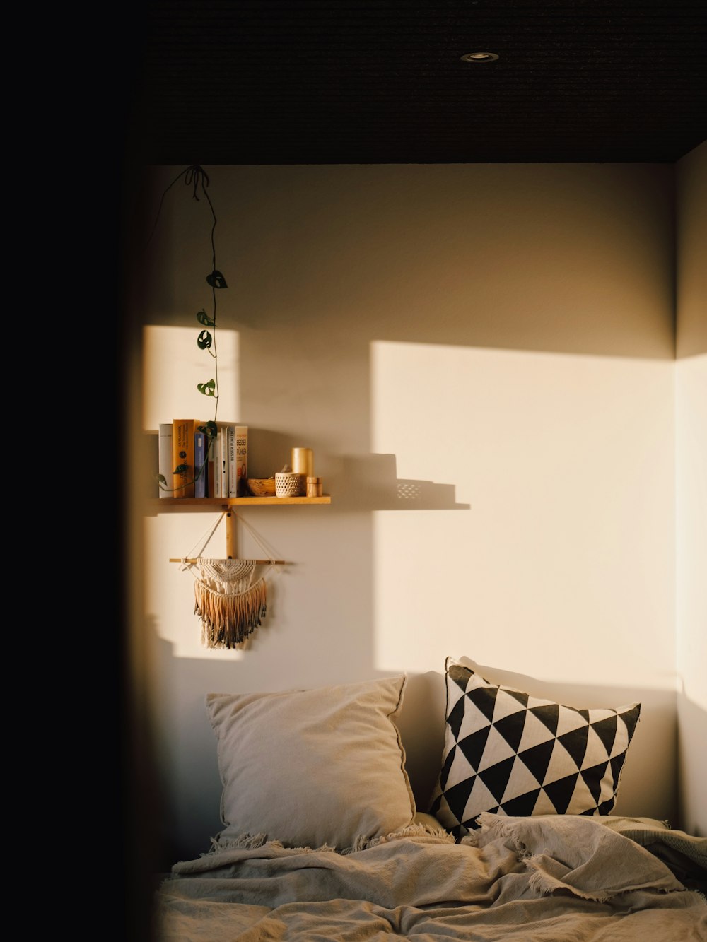 a bed with a black and white pillow on it