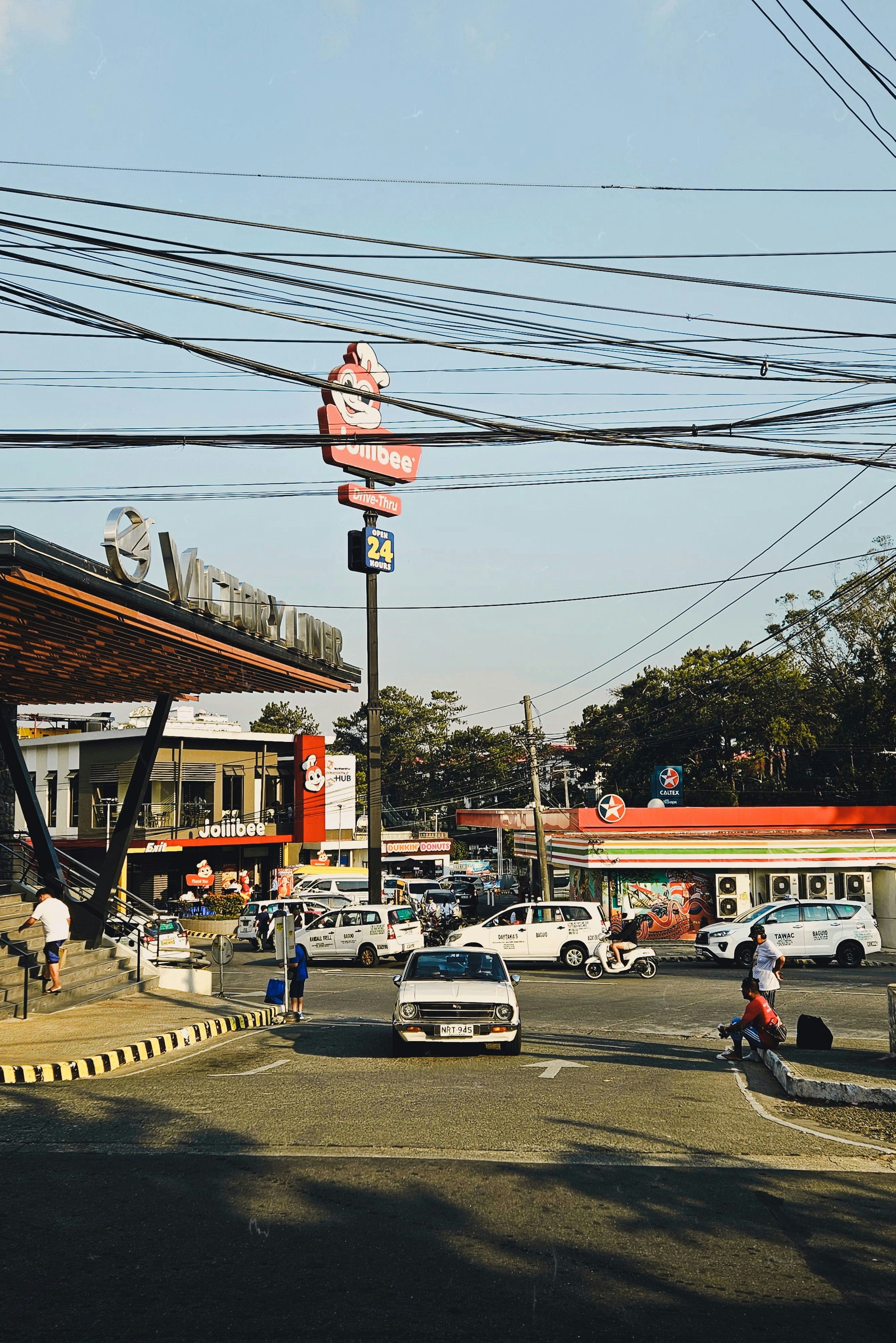a gas station with cars and people on the street