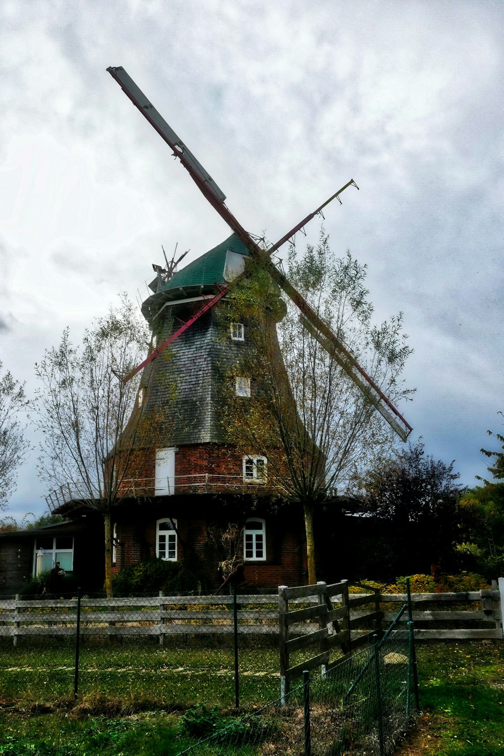 a windmill sitting on top of a lush green field