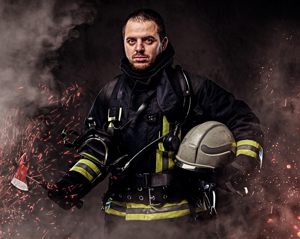 a firefighter holding a helmet and fire hose