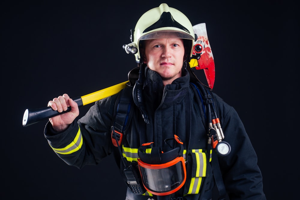 a firefighter holding a fire hose and a helmet