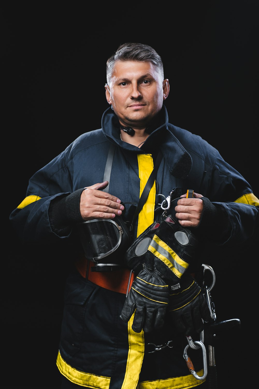 a man in a fireman's uniform holding a pair of gloves