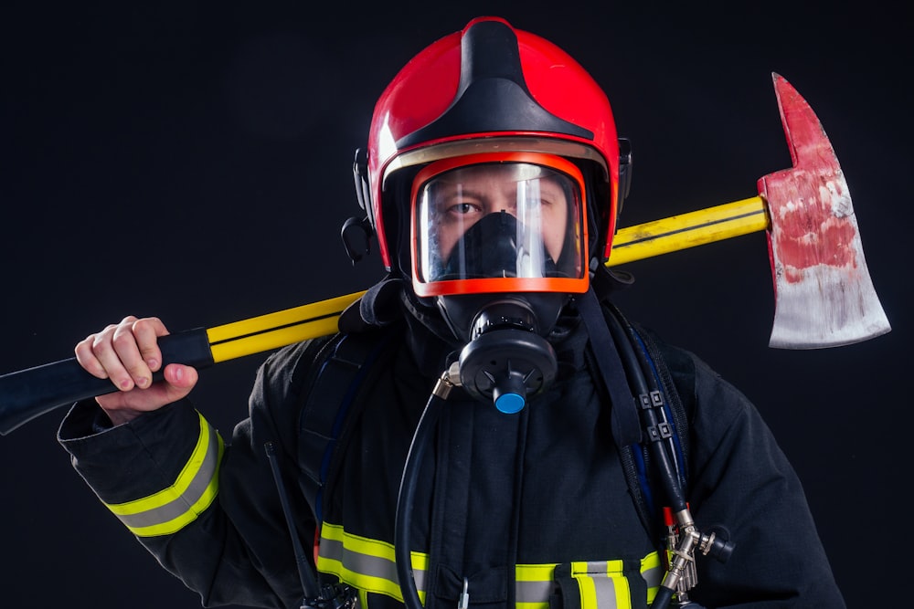 a fireman holding a large axe and wearing a helmet