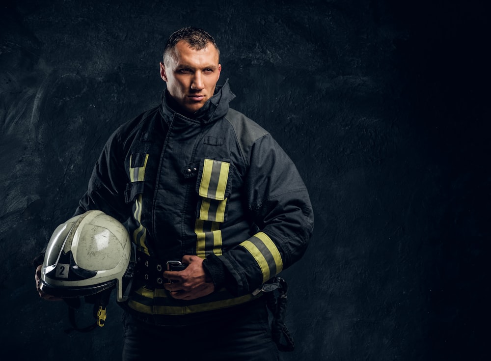 a man in a fireman's uniform holding a helmet