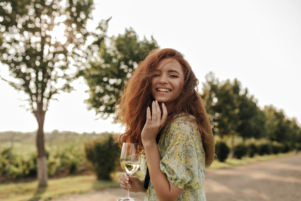 a woman holding a glass of wine and smiling