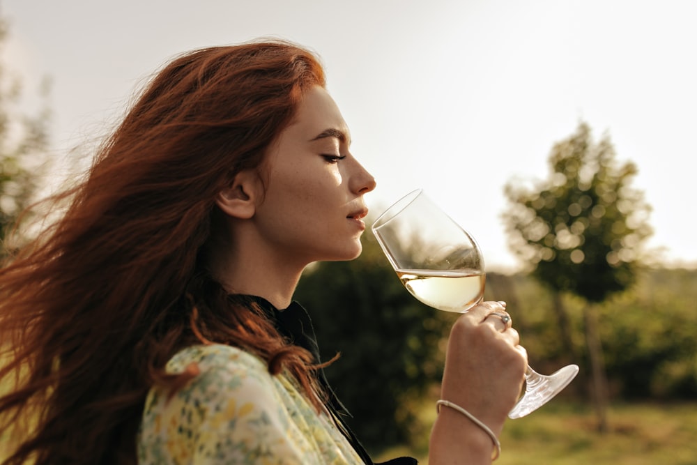 a woman drinking a glass of white wine