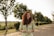 a woman standing on a road holding a glass of wine
