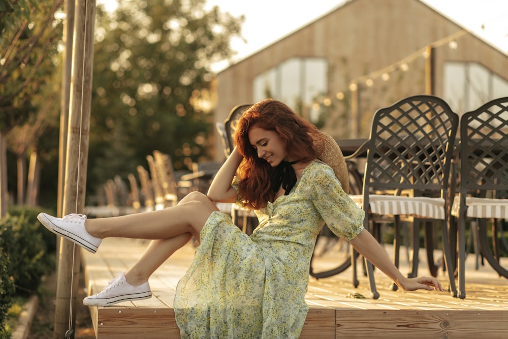 a woman in a green dress sitting on a wooden bench