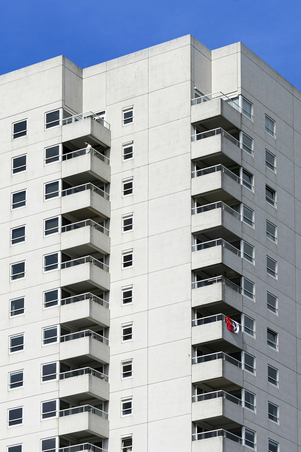 a tall white building with balconies on the top of it