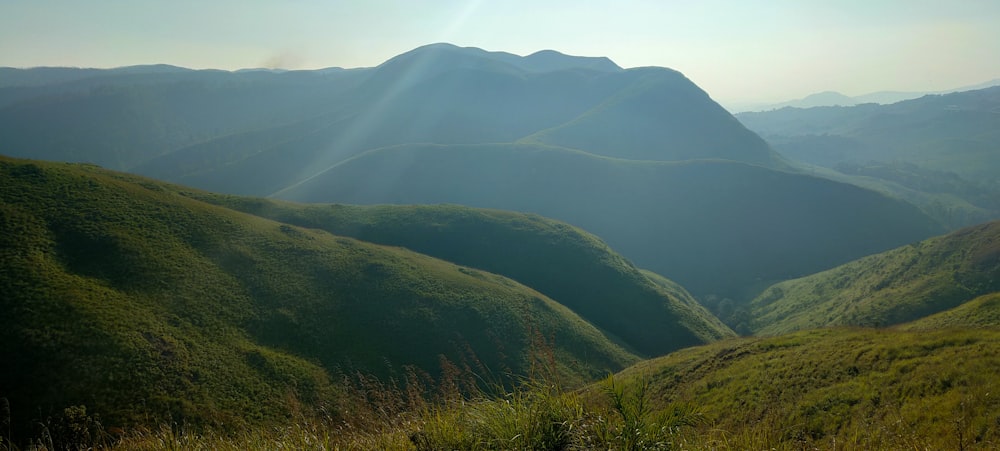 the sun shines on the mountains in the distance