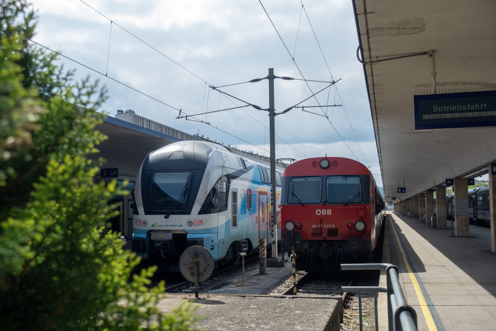 two trains parked next to each other at a train station
