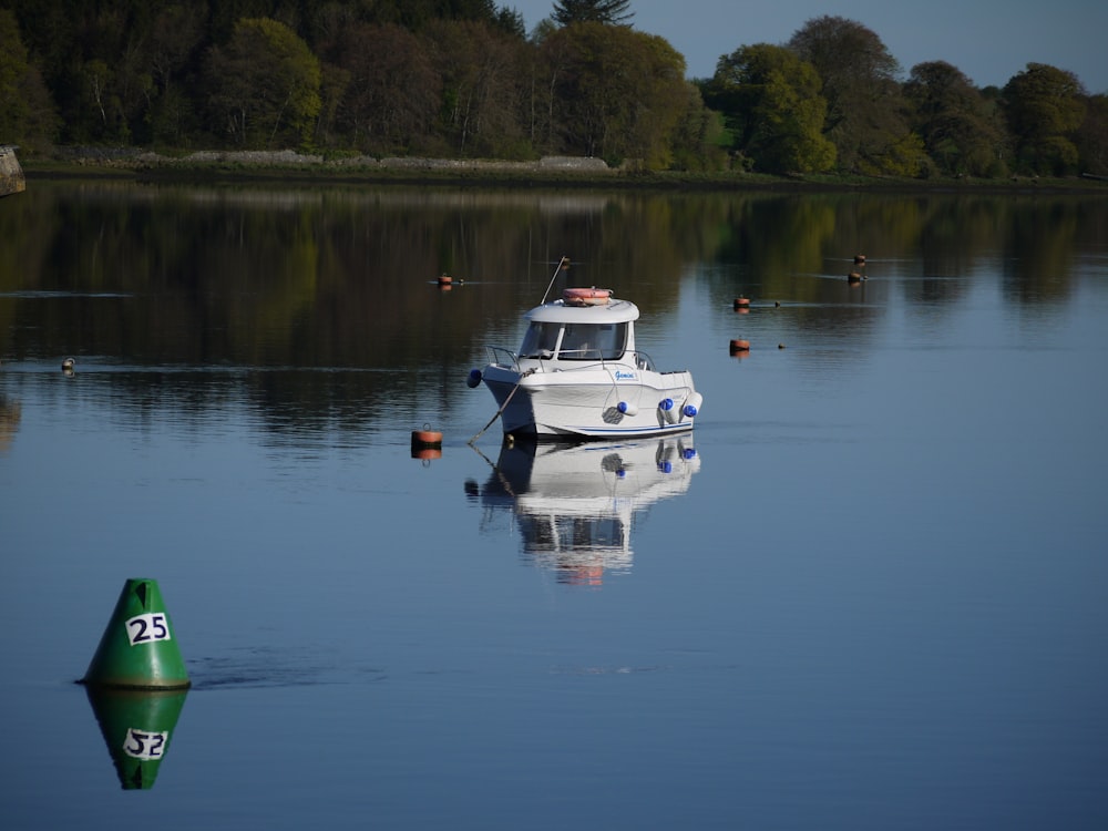 un bateau blanc flottant au-dessus d’un lac