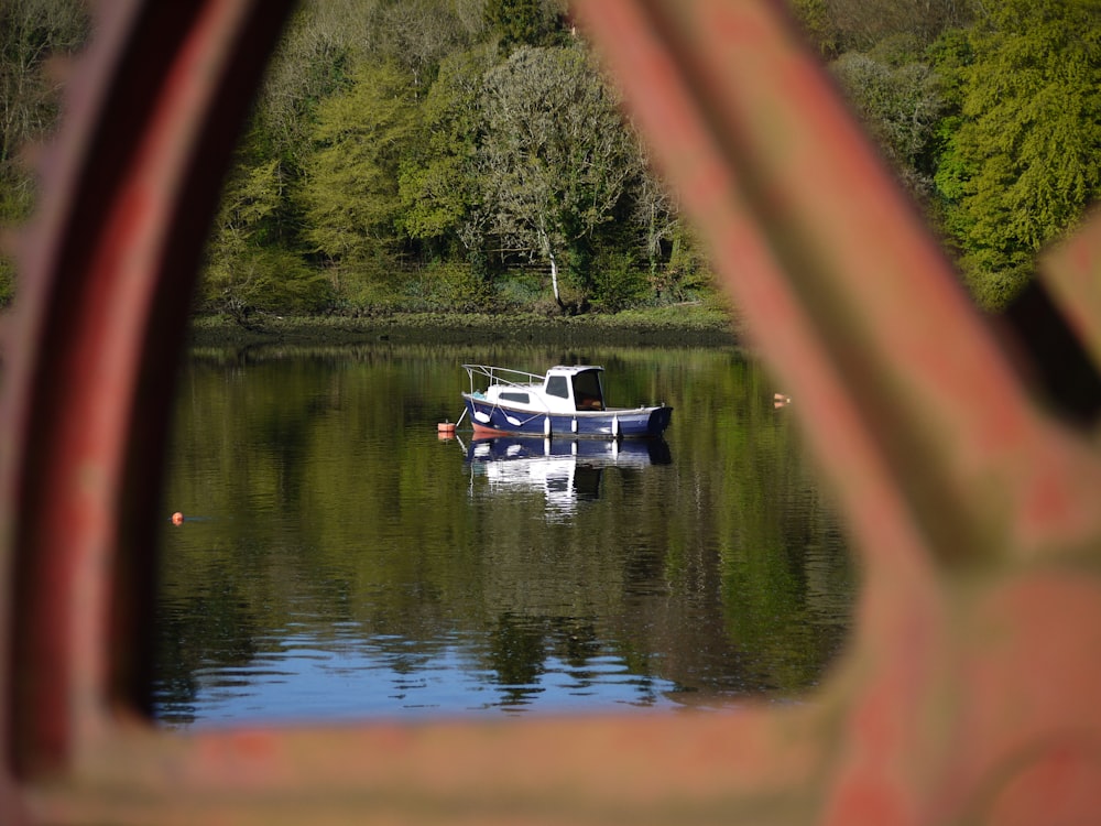 a boat floating on top of a lake next to a forest