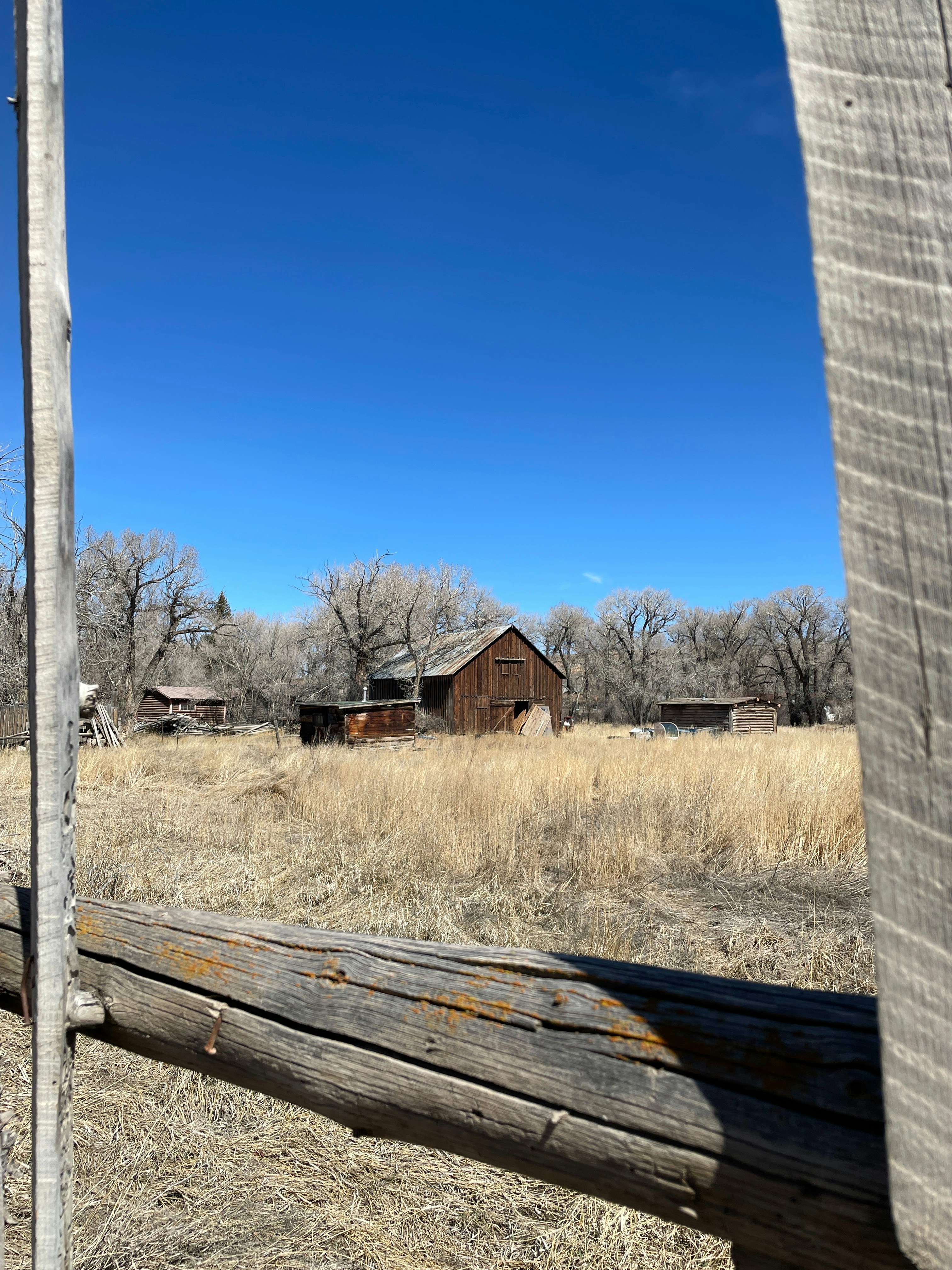 an old barn in the middle of a field